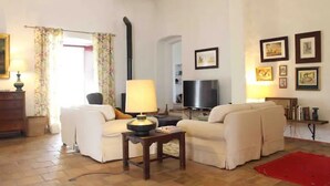 A living room with two sofas, a TV, a lamp, and a fireplace.