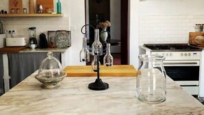 A kitchen with a marble countertop, a stove, and a sink.