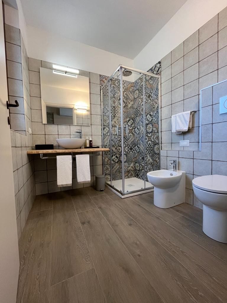 Un bany modern amb plat de dutxa, un lavabo, un vàter i un lavabo.