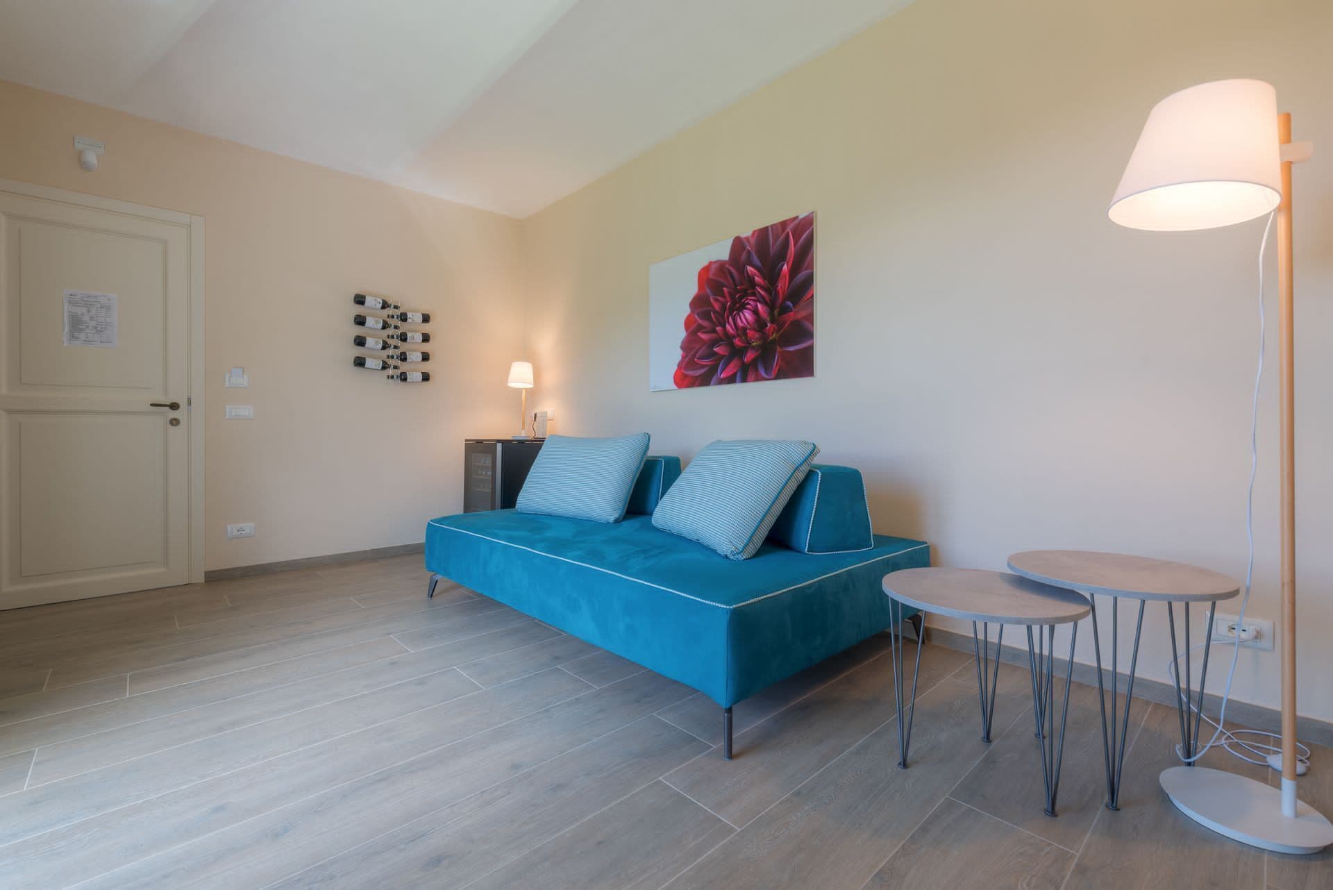 Un salon moderne avec un canapé bleu, une petite table ronde et un lampadaire.