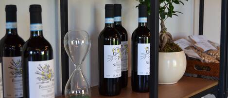 A shelf with wine bottles, an hourglass, and a potted plant.