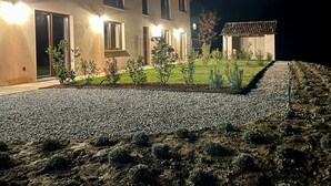Un bâtiment à deux étages avec une allée en gravier et un petit jardin.