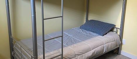 A bunk bed with a metal frame, a mattress, and pillows.