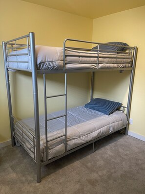 Ein Stockbett mit Metallgestell, einer Matratze und Kissen.