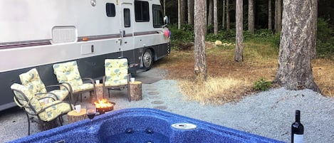 A recreational vehicle with a hot tub and outdoor seating.