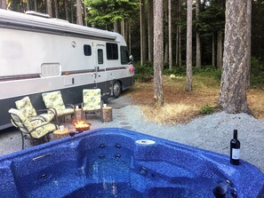 Ein Wohnmobil mit Whirlpool und Sitzgelegenheiten im Freien.