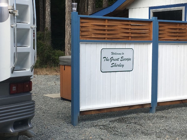 Un véhicule est garé devant une entrée fermée par un portail, sur lequel on peut lire : « Bienvenue à The Great Escape Shirley. »