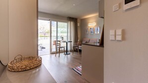A modern living room with a sofa, a dining table, and chairs. There is a large window with a view of the outdoors. - Mali Apartments with balcony and nice views (Tirolo)