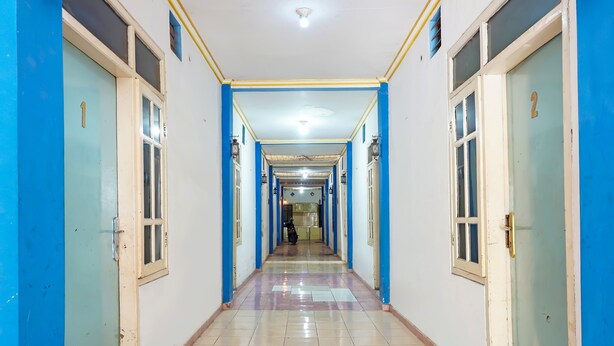 A long, narrow hallway with doors numbered 1 and 2 on either side, leading to rooms. - OYO 91766 Fortuna Hotel Syariah (Paiton)