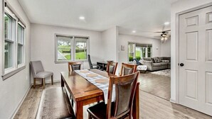 A dining area with a wooden table and chairs, a sofa, and a ceiling fan. - Recently remodeled home with bedrooms and living spaces on the ground floor (Smithville)