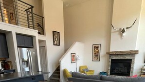 A modern living room with a round dining table, leather chairs, a sofa, and a fireplace. - Our Happy Place -Downtown Dazzling S Mountain View (Salida)