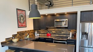 A modern kitchen with a central island, bar stools, a hanging pendant light, a stainless steel refrigerator, and a microwave above the island. - Our Happy Place -Downtown Dazzling S Mountain View (Salida)