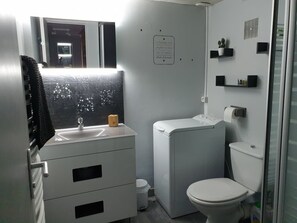 A compact bathroom with a white sink, a toilet, and a compact washing machine. - Ty Aziliz, Charmante Petite Maison Bretonne (Saint-Barthelemy)