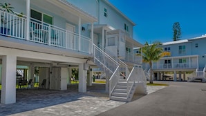 A multi-story hotel with outdoor seating and a staircase leading to the upper floors. - Blue Octopus Hideaway at OI! (Marathon)