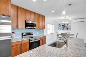 Enjoy cooking in this fully equipped kitchen with a refrigerator, microwave, and oven, and dine at the adjacent table.