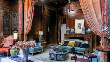 A traditional room with a sofa, chairs, a table, and a decorative vase.