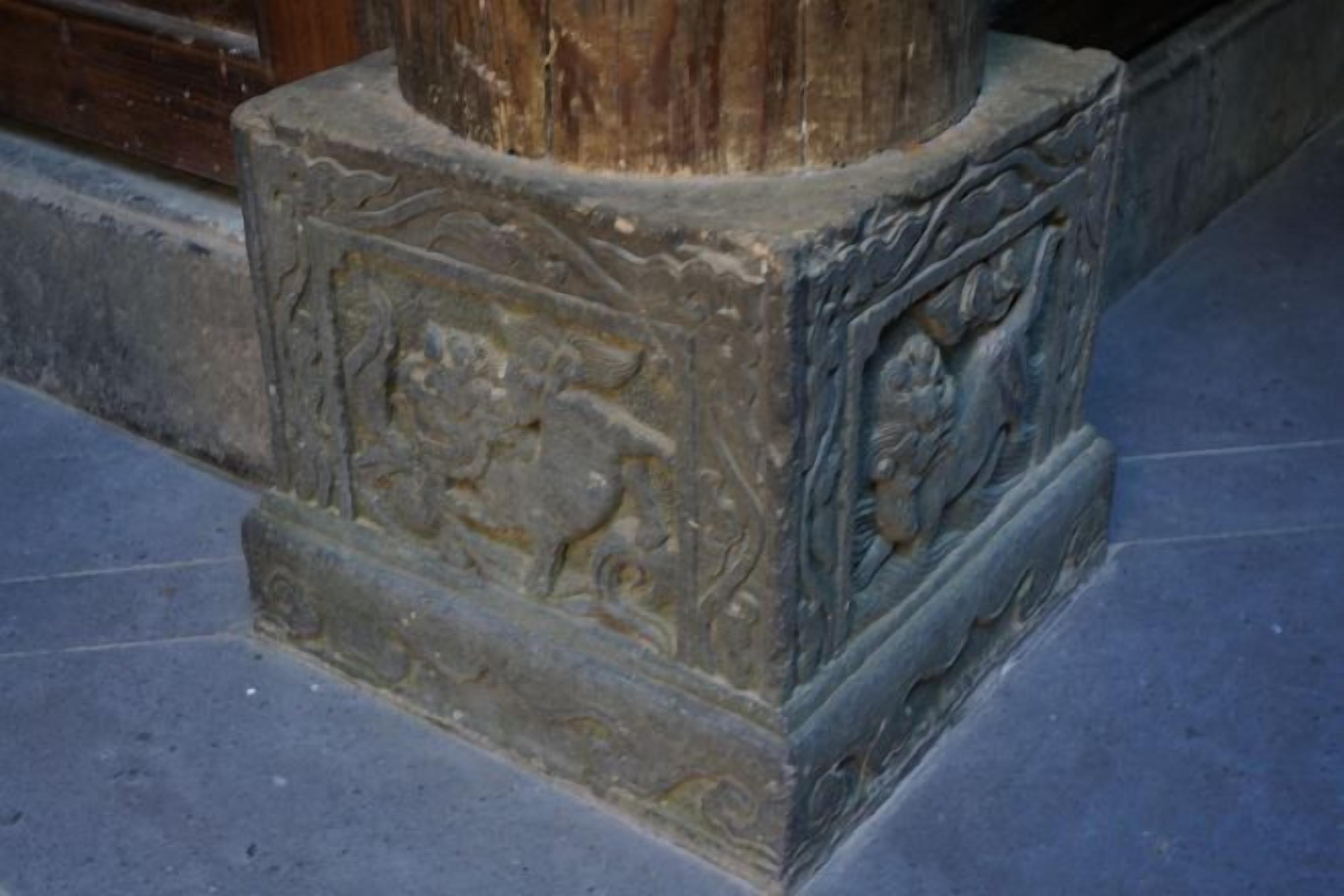 A stone pillar with intricate carvings, possibly depicting historical or cultural scenes.
