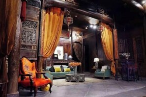 A traditional interior with a sofa, armchairs, and a table. - Ruiqi Xiangyun Inn (Yi County)