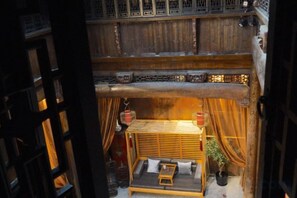 Una habitación tradicional con techo de madera, una cama con almohadas y un farol colgante.