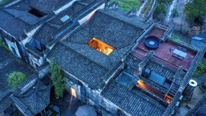 An aerial view of a traditional courtyard with multiple buildings, a central open space, and a small pool. - Ruiqi Xiangyun Inn (Yi County)