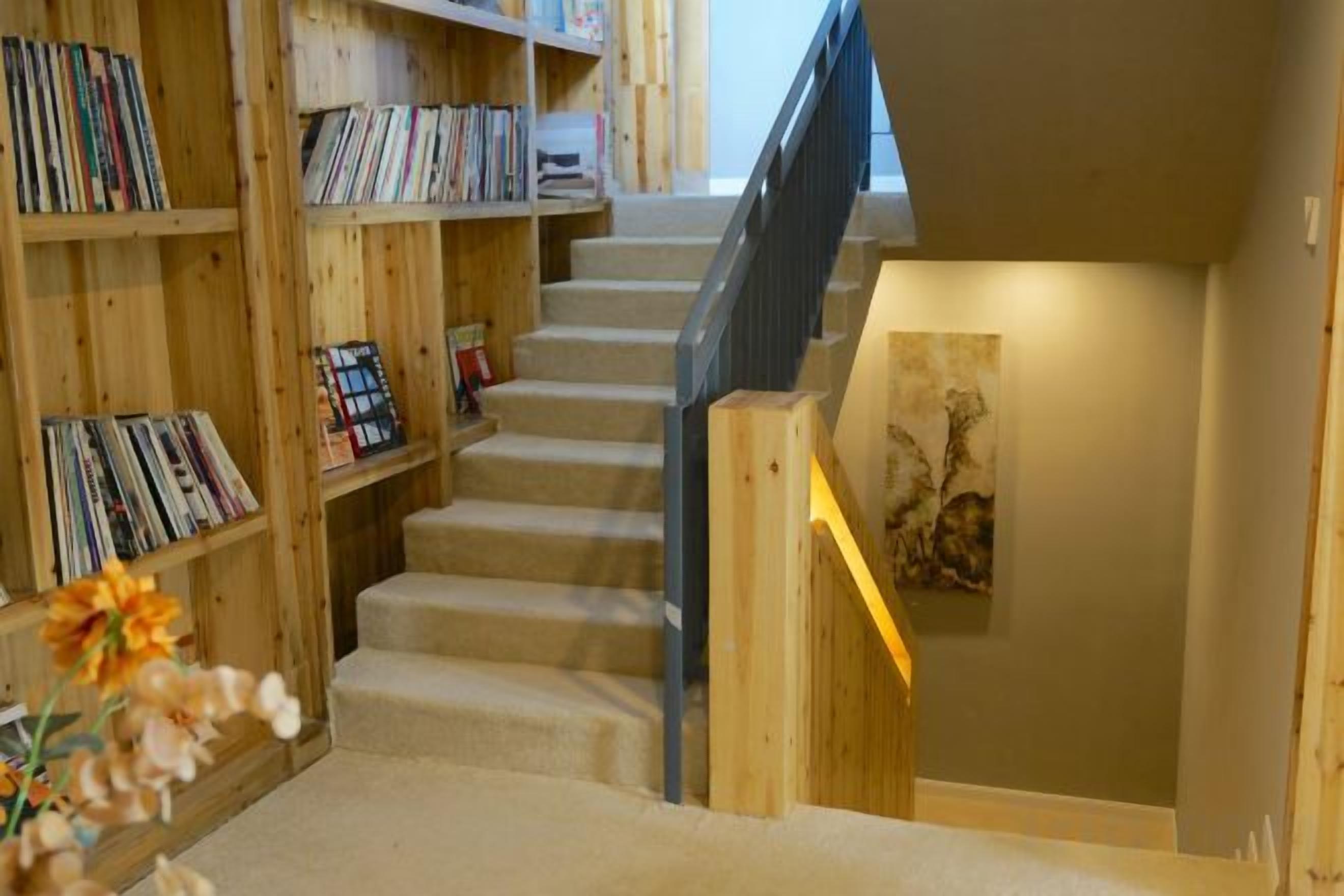 A staircase with bookshelves on either side, leading to a lower level.