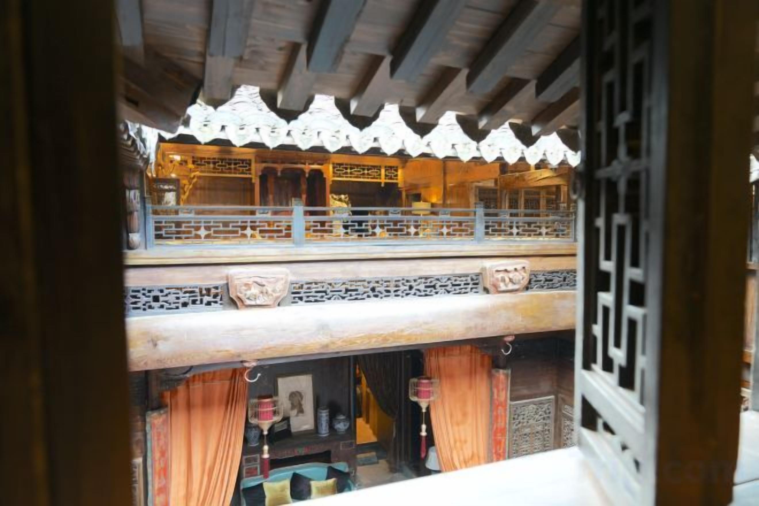 A traditional building with a wooden balcony and intricate lattice work.