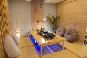 Een traditionele Japanse kamer met tatami vloeren, een lage houten tafel en een sofa van tatami matten.
