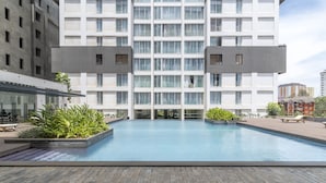 A modern hotel with a large pool area, outdoor seating, and a courtyard with plants. - Purple Haze by Aircasa (Nairobi)