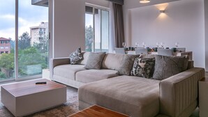 A modern living room with a sofa set, a coffee table, and a dining area with a table and chairs. - Purple Haze by Aircasa (Nairobi)