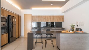 A modern kitchen with a central island, built-in appliances, and a minimalist design. - Purple Haze by Aircasa (Nairobi)