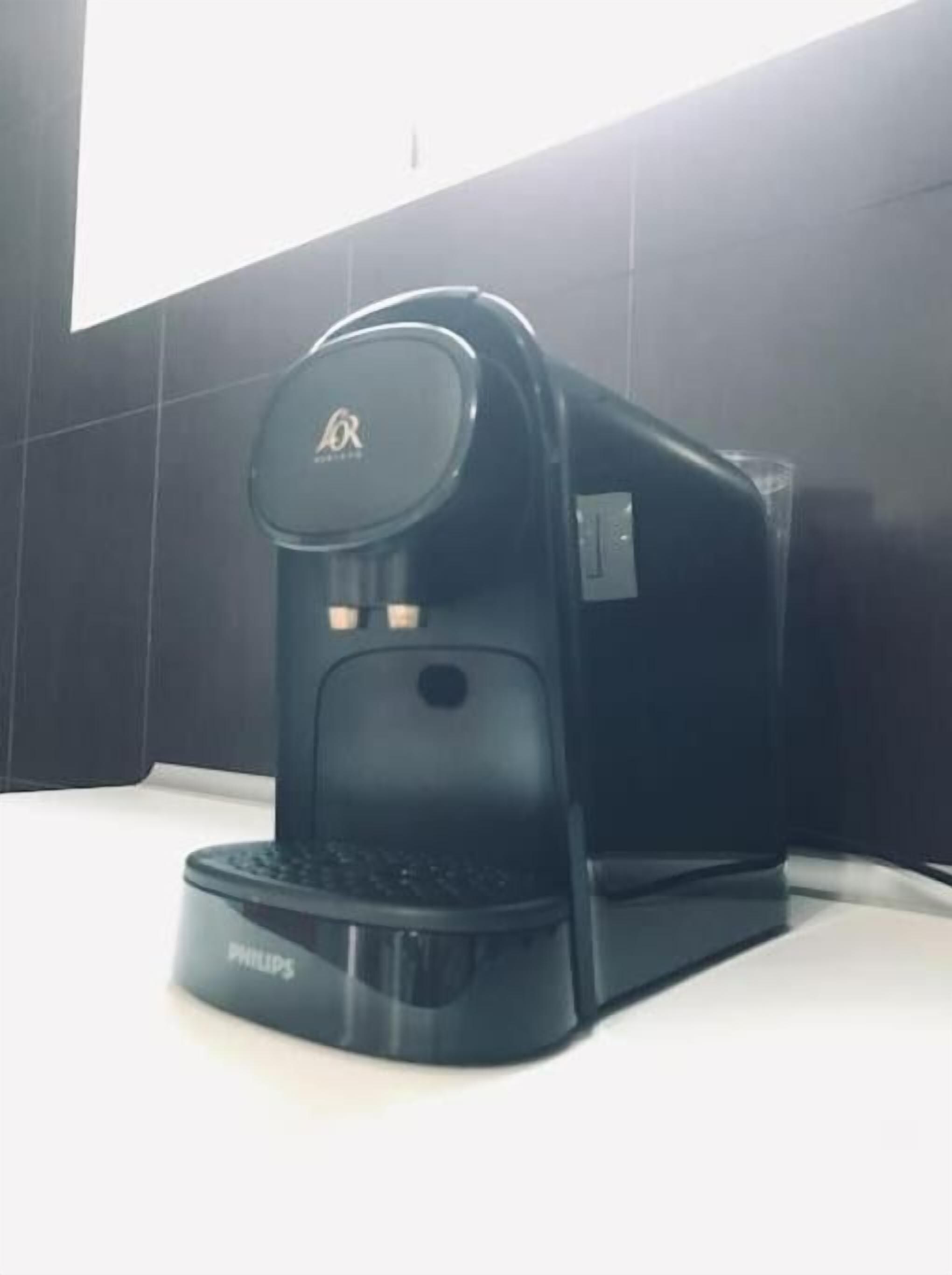 Eine schwarze Kaffeemaschine mit Philips-Logo auf einer weißen Arbeitsplatte.