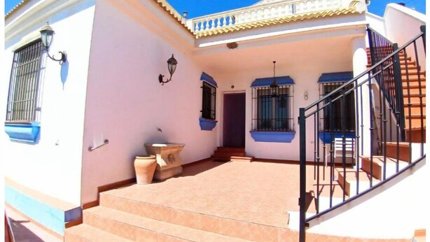 A two-story house with a tiled patio, a staircase, and a small garden area. - El Mirador de Pablo, Casa con Patio Privado (Alomartes)