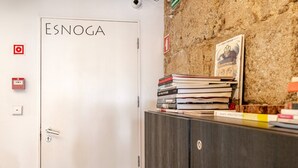Ein Zimmer mit einer weißen Tür, auf der „ESNOGA“ steht, einem an der Wand montierten Rauchmelder und einem Bücherstapel auf einem Holzschrank.