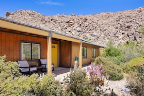 A modern building with a wooden exterior, large windows, and a yellow door. - Moonbeam Mountain - Stylish Suites + Hot Tub (Joshua Tree)