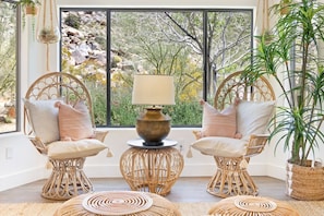 A room with two wicker chairs, a table with a lamp, and a potted plant. - Moonbeam Mountain - Stylish Suites + Hot Tub (Joshua Tree)