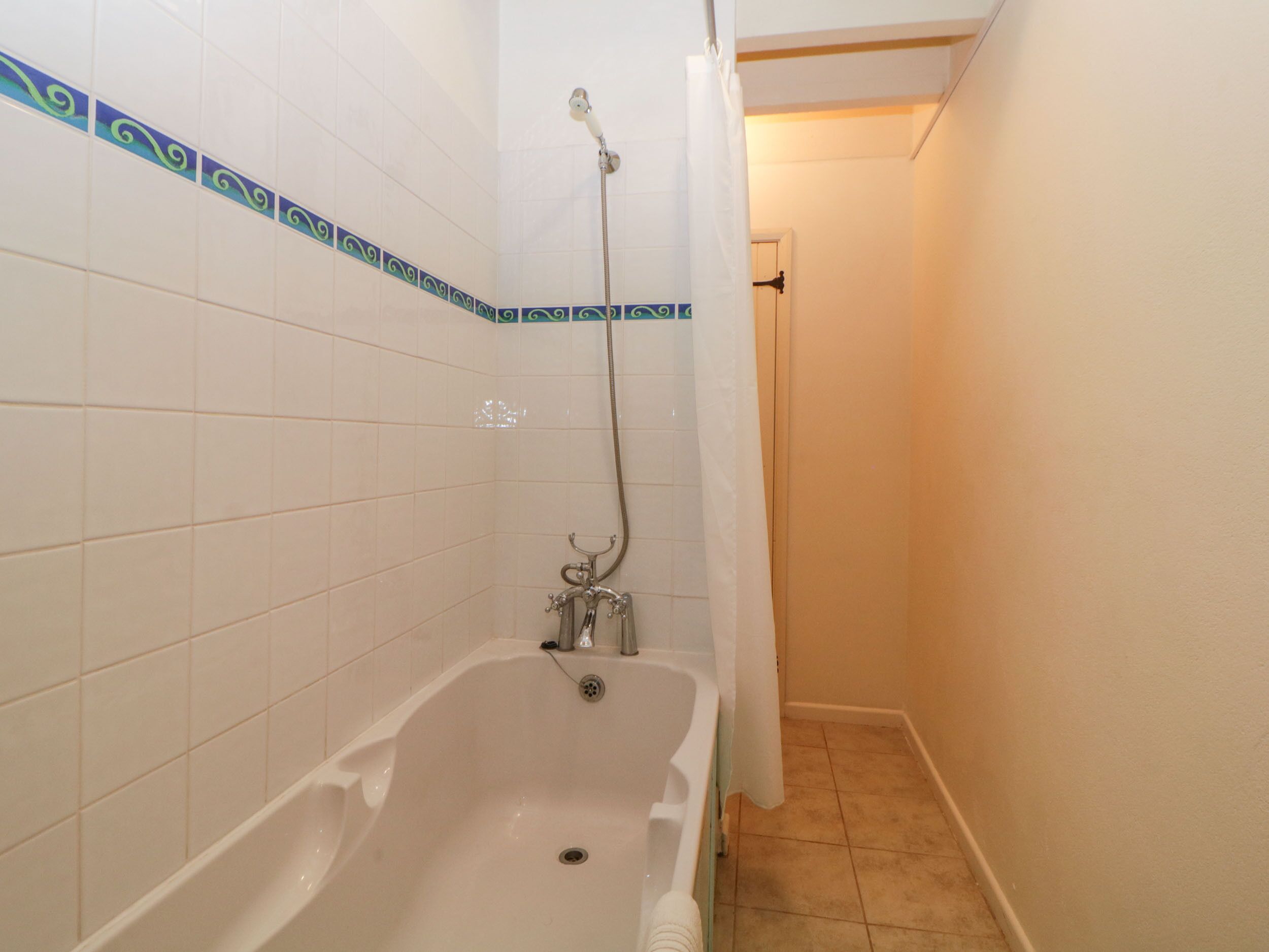 A bathroom with a bathtub, a shower, and tiled walls.