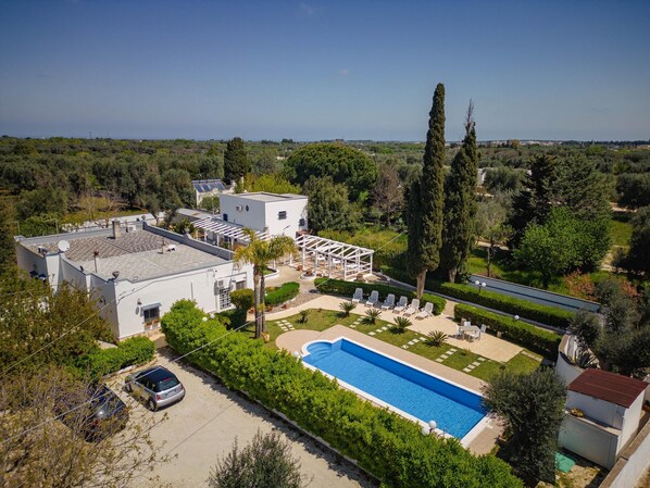 Una villa moderna con piscina, un espacio de estar cubierto al aire libre y vistas del paisaje circundante.