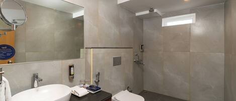 A modern bathroom with two sinks, a bidet, a shower, and a large mirror.