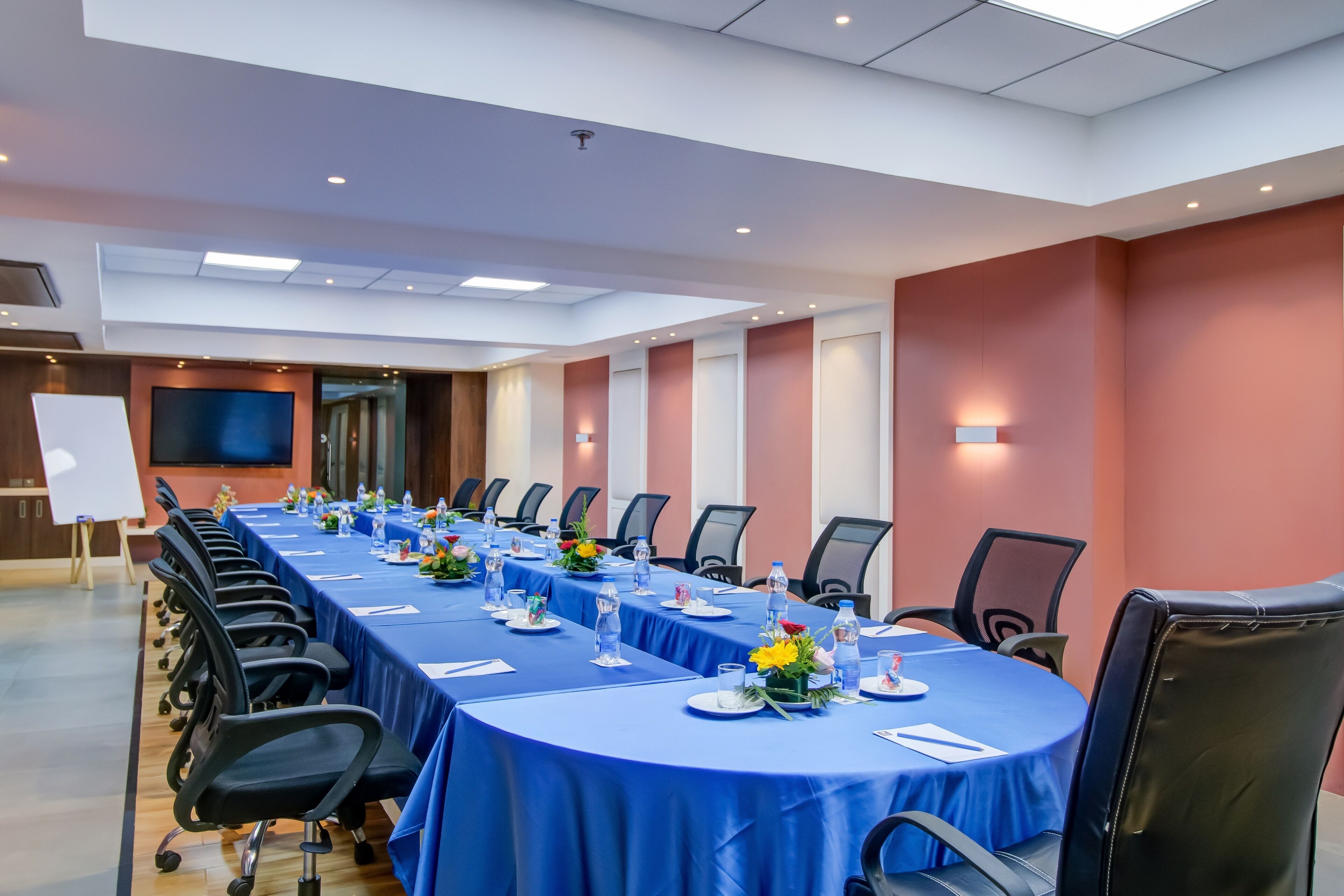 A conference room with a long table, chairs, and a whiteboard.