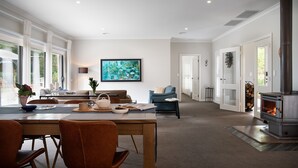 Un salón amplio con zona de comedor, chimenea y un ventanal grande.