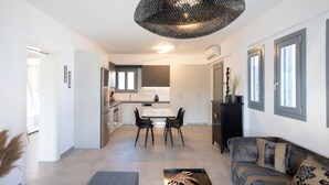 A modern living room with a sofa, a coffee table, and a dining area with a table and chairs.