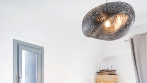A modern living room with a sofa, a coffee table, a cabinet, and a hanging light fixture.