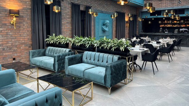 A modern lounge area with plush seating, a bar, and a high ceiling with skylights. - Richmond Hotel (Chisinau)