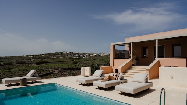 Un espace piscine doté de chaises longues et d’un escalier menant à un niveau supérieur.