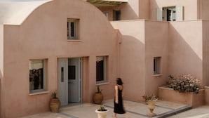 Un bâtiment à la façade incurvée, doté de nombreuses fenêtres et orné de plantes en pot.