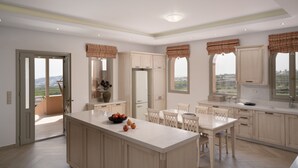 Une cuisine spacieuse dotée d’un îlot central, de meubles en bois et de grandes fenêtres offrant une vue sur l’extérieur.