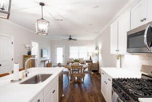 Enjoy cooking in this well-equipped kitchen with a central island, gas stove, and stainless steel sink.