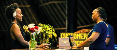 A bar area with a counter, a laptop, and a sign that reads "CUSTOMER SERVICE".
