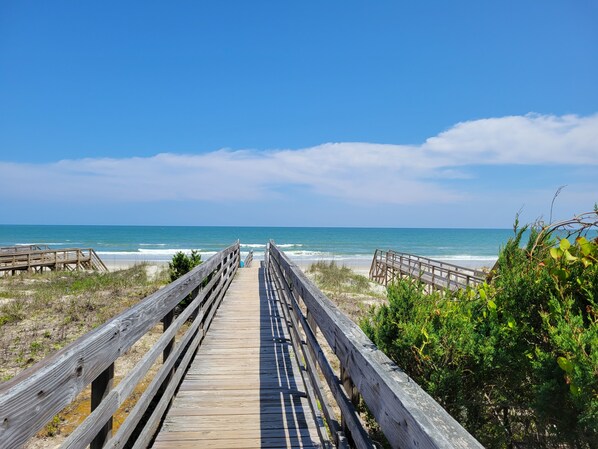 A wooden boardwalk leading to a beach with a clear blue sky. - Raised 2-Story Beach House, Beautiful Updates, Private Pool, Shortcut to Beach (Pawleys Island)