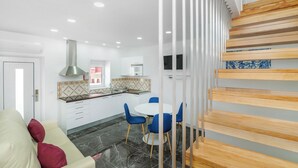 Una cucina moderna con mobili bianchi, una cappa in acciaio inossidabile e una finestra vista sala da pranzo.